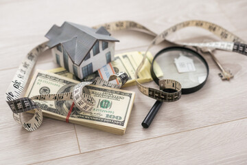 dollar, toy house next to a magnifying glass, sale of real estate, rental housing