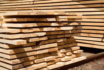 Stack of fresh pine boards in a sawmill warehouse. Harvesting, sale of lumber for construction	