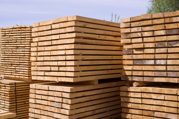 Stack of fresh pine boards in a sawmill warehouse. Harvesting, sale of lumber for construction	 - obrazy, fototapety, plakaty