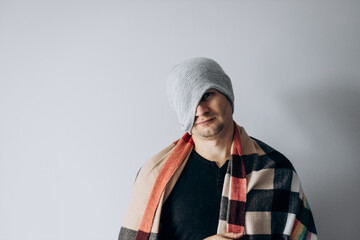 Guy is wrapped in blanket and warms his hands from the cold. Heating season. Winter has come,...