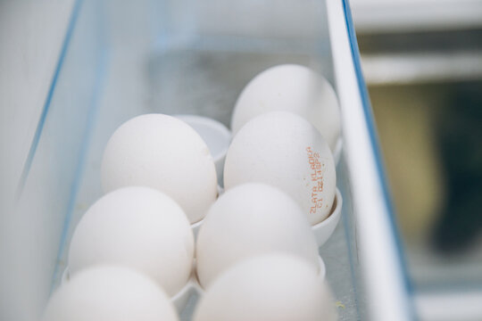 World Egg Day and raw brown and white chicken eggs in a container in the refrigerator tray. The concept of natural healthy food and organic food. world egg day.