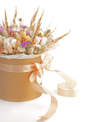 Beautiful bouquet of dry flowers in hat box with ribbons isolated on a white background. Empty space for your text.