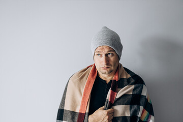 Guy is wrapped in blanket and warms his hands from the cold. Heating season. Winter has come,...
