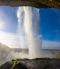 view from behind the seljalandsfoss waterfall in iceland