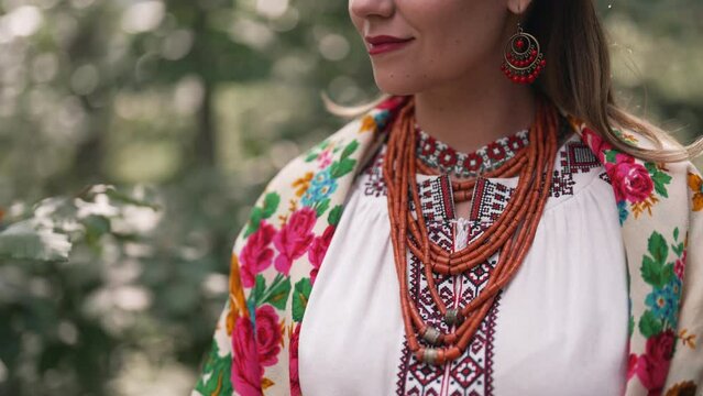 Pretty woman in traditional ukrainian jewelry necklace, dress, handkerchief and gerdan. Lady in national costume - vyshyvanka and ancient coral beads on forest nature background