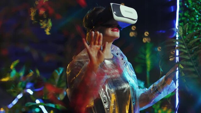 smiling trendy woman in virtual reality in vr headset pressing the button in the air.
