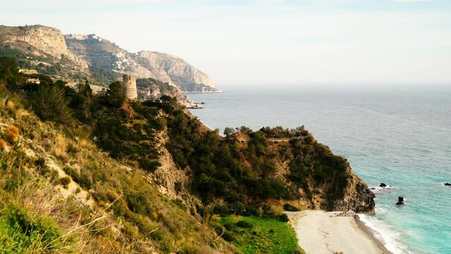 Coastal landscape with watchtower. Torre Del Pino, tower on cliffs of Maro Cerro Gordo Natural Park, near Maro and Nerja, Malaga province, Costa Del Sol, Andalusia, Spain. Tourist attraction.