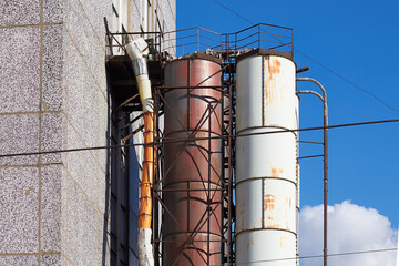 Industrial pipes from the end of the building, rusty old pipes on the side of the facade of the house
