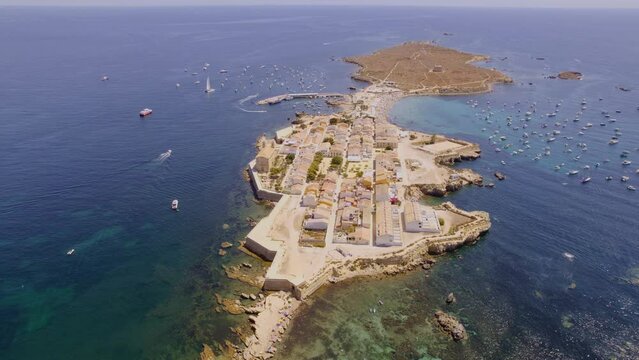 Aerial view of Tabarca island with boats at anchor. Mediterranean Sea. Popular travel destinations at summer. Spain. Cinematic 4K