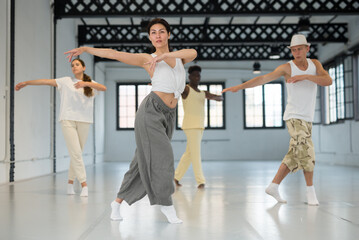 Confident asian female dancer enjoying dancing break dance with her team at rehearsal studio room