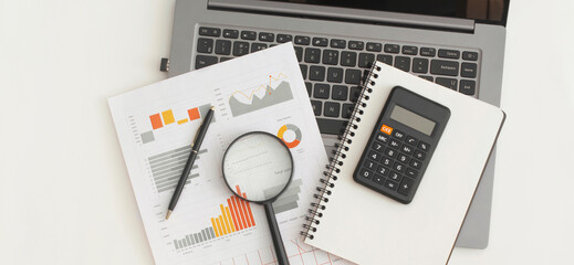Business graphs, charts, laptop, magnifying glass and calculator on table. Financial development, Banking Account, Statistics