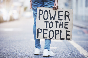 Power to the people cardboard protest poster in a city street for politics, government or human...