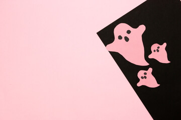 pink ghosts on black part of black and pink background, halloween minimal art design, next to ghosts copy space, flat lay
