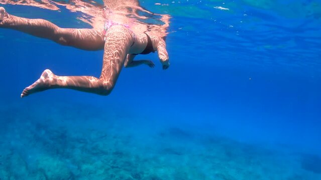 Slow motion of woman snorkeling in blue sea with mask