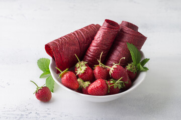 Homemade strawberry pastille with fresh strawberries on a light blue background