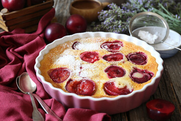 Red plums clafoutis (flan), icing sugar dressing, french cuisine