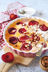 Red plums clafoutis (flan) with almonds, icing sugar dressing