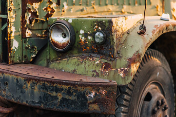 Headlight front of an old, rusty, abandoned, military, truck car with cracked paint. Photo of the...