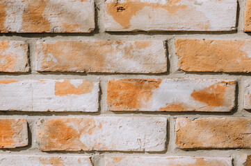 Texture, background of brown, orange bricks on the wall in spots. Photography, architecture.