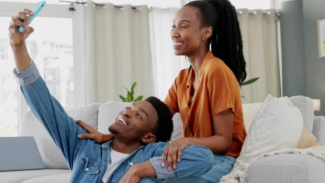 Smile, selfie and a phone, a couple on sofa in living room at home. Friends, lovers and partners, a happy man and black woman in love, on couch taking picture or video on smartphone for social media.