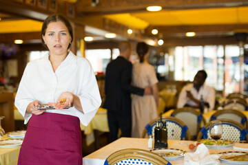 Female waiter demonstrating his upset with little tips from restaurant visitors