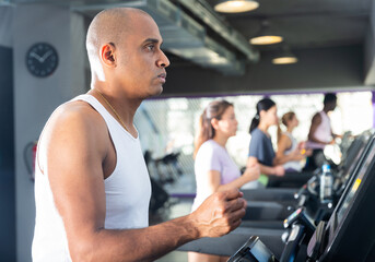 Fototapeta na wymiar Man running on a treadmill in a sports club