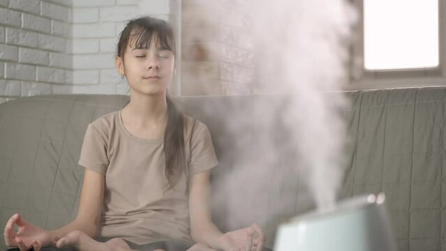 Girl aroma therapy from humidifier. A teenage girl like her aroma therapy exercices in the white steam in the room.