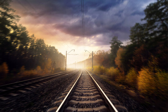 Railroad In The Autumn Forest. Railway Tracks Through The Forest. Motion Blur Effect.