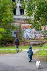 Three people on the road in autumn: father, son and dog. locomotive