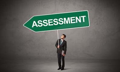 Obraz premium Young business person in casual holding road sign