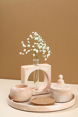 Modern cement concrete home decor in pastel beige colors, abstract vase with gypsophila flowers and...