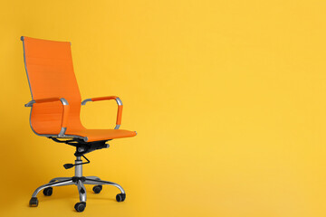 Modern office chair on yellow background. Space for text