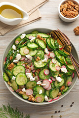 Delicious cucumber salad served on white wooden table, flat lay