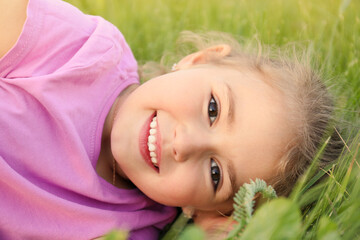 Obraz na płótnie Canvas Cute little girl on green grass, closeup