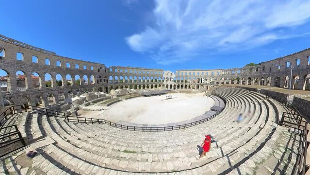 Tourist woman inside Pula Amphitheater or Coliseum of Pula is a well-preserved Roman amphitheater, located in Pula, Istria, Croatia, Europe. Ancient Roman empire arena constructed in 27 BC - 68 AD.