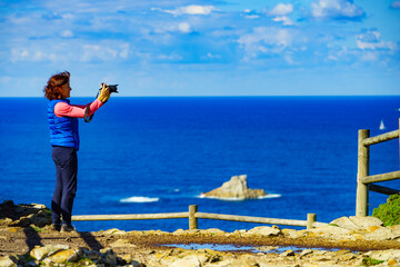 Tourist with camera on Asturias coast, Spain