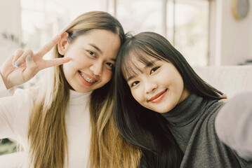 Young adult Asian woman smiling, waving and looking at camera, distance learning, online teaching, video conference concept