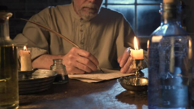 18th century man writing at his desk with a quill pen