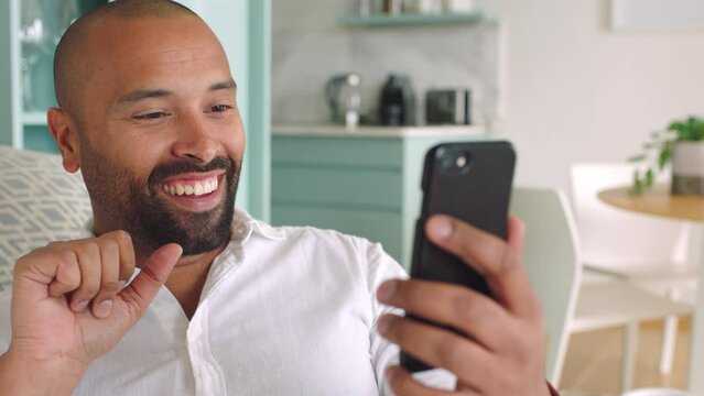 Smartphone, video call and black man in living room networking with home wifi and doing rock sign for online user. Relax person with mobile app virtual zoom communication for global connection