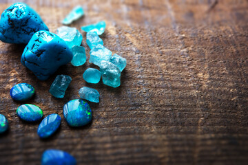 Blue gems on rustic wooden table. Treasure hunting. Mining for gems. Blue Turquoise, blue opals and...