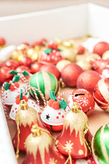 Box of mixed Christmas tree ornaments, balls and bells in the classic traditional colors of red, green, white and gold.