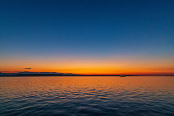 An orange sunset casts a reflection over Puget Sound
