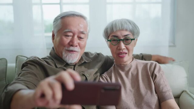 sweet old senior marry couple talking selfie photo together while casual relax leisure sit on sofa in living room at home,asia old people couple stay home together