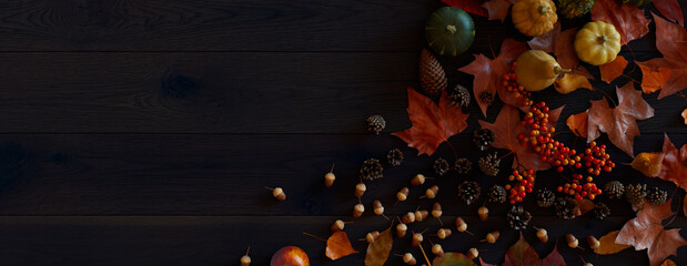 Top down view of Dark wood Tabletop with leaves, Pumpkins and Pine cones.