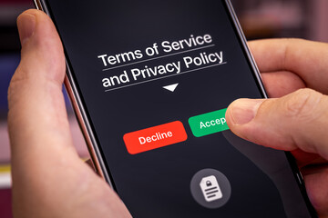 Smartphone user agrees to accept Terms of Service and Privacy Policy mobile app. Finger touches the Accept button. Dark app interface with Accept and Decline buttons - obrazy, fototapety, plakaty