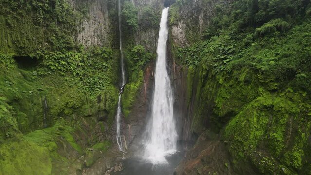 One of Costa Rica's tallest waterfalls cascading into pool - Catarata del Toro in picturesque lush nature setting; drone view