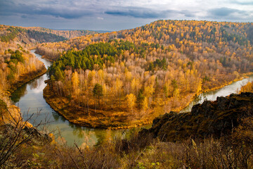There is beautiful place called Berdsk cliffs or Berdskie skaly in Novosibirsk region. Rocks in these places composed of igneous rocks. Top view of Berdsk river bend, autumn forest. Scenic landscape
