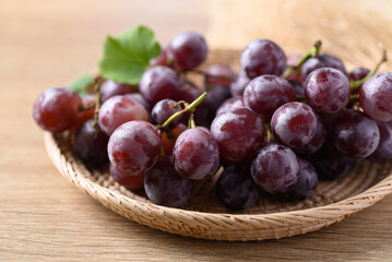 Red grape in basket on wooden background, Healthy fruit