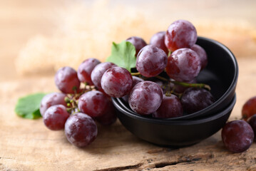 Red grape in bowl on wooden background, Healthy fruit