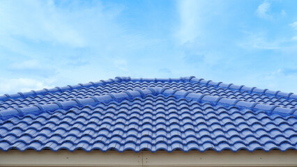 Blue roof tiles arranged on the roof. Hip Roof of the house is beautifully lined. Construction of a...